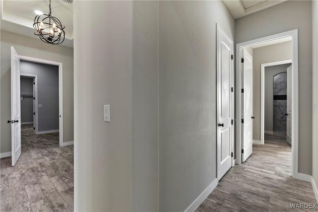 hallway featuring light wood-style floors and baseboards