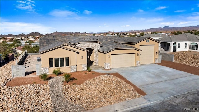 single story home featuring a mountain view, stone siding, a residential view, and stucco siding