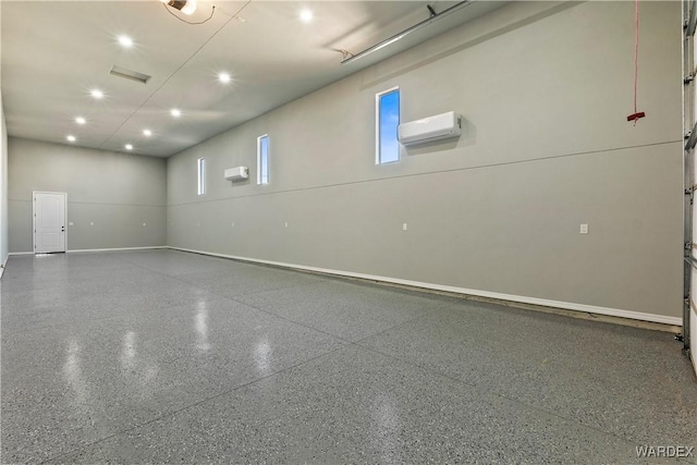 interior space featuring recessed lighting, an AC wall unit, baseboards, and speckled floor