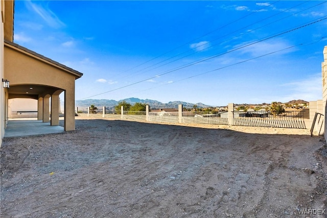 view of yard with a mountain view, a patio, and fence