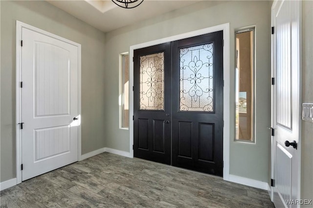 foyer with baseboards and wood finished floors