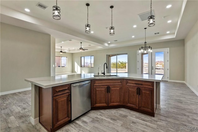 kitchen featuring dishwasher, light countertops, a large island, and a sink