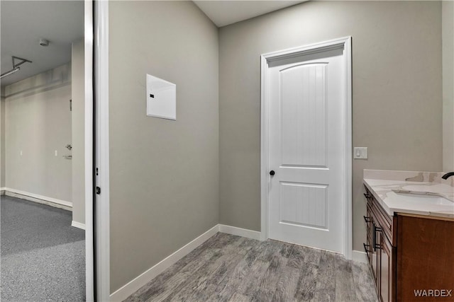 bathroom with baseboards, wood finished floors, and vanity