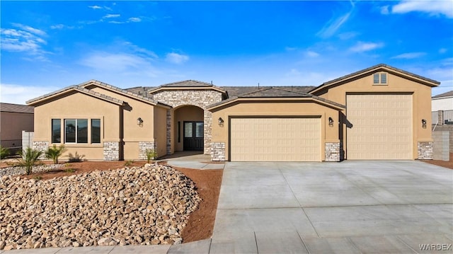 single story home with a garage, stone siding, driveway, and stucco siding