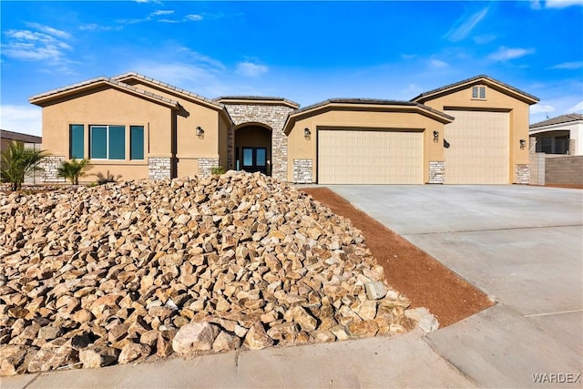 view of front of home with a garage, stone siding, driveway, and stucco siding