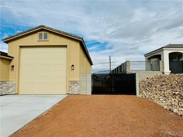 garage with driveway and a gate