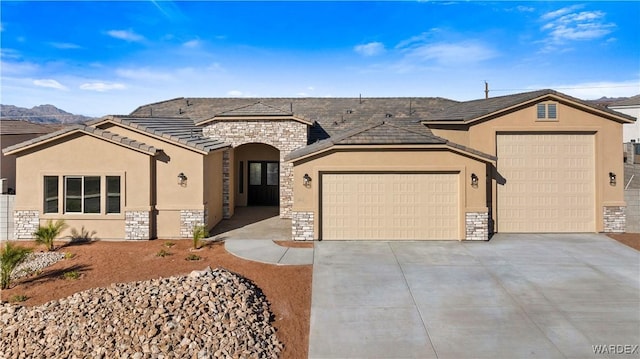 view of front of property with a garage, stone siding, concrete driveway, and stucco siding