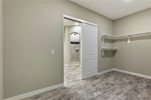 walk in closet with wood finished floors