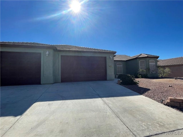 view of front facade featuring an attached garage, concrete driveway, and stucco siding