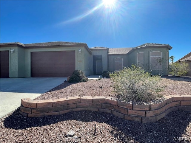 view of front of property with a garage, concrete driveway, and stucco siding