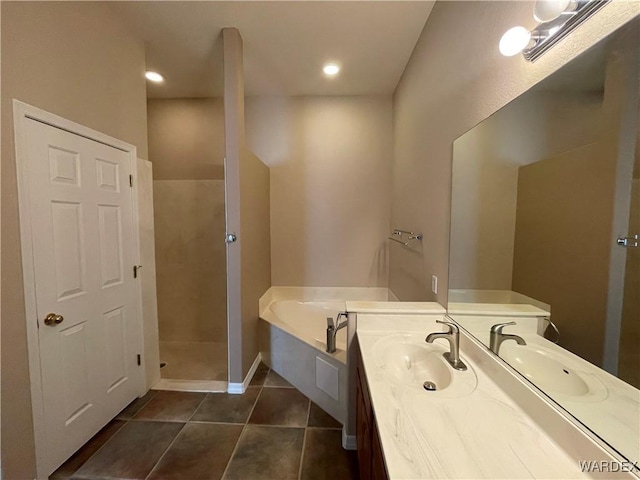 bathroom featuring tile patterned flooring, a garden tub, and vanity