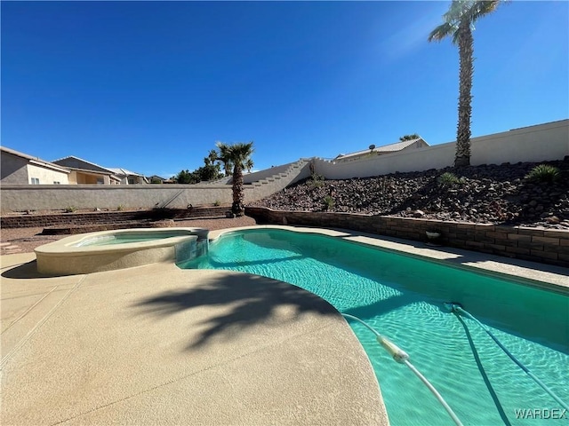 view of pool featuring a fenced backyard and a pool with connected hot tub