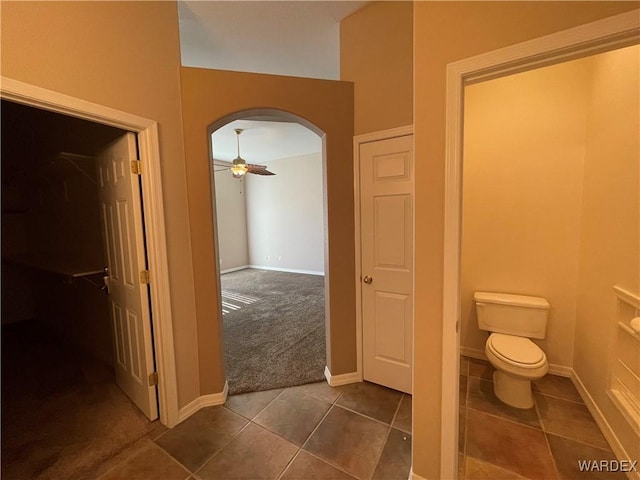 bathroom featuring toilet, ceiling fan, baseboards, and tile patterned floors