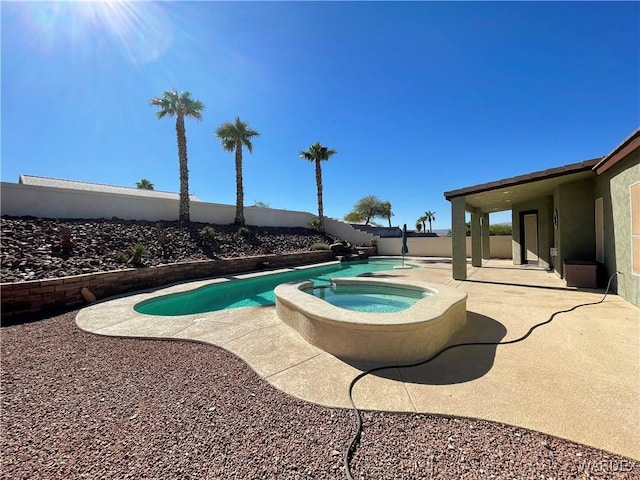 view of swimming pool with a fenced backyard, a pool with connected hot tub, and a patio