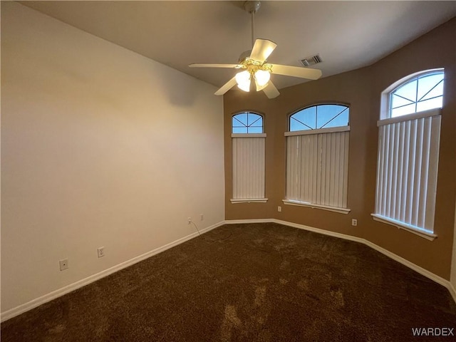 carpeted spare room with ceiling fan, visible vents, and baseboards