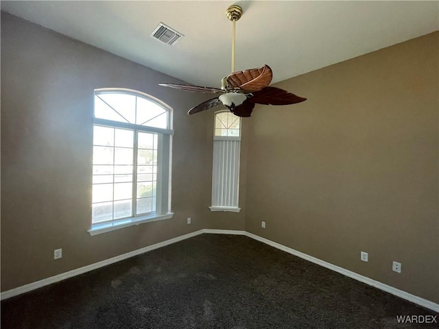 carpeted spare room featuring visible vents, ceiling fan, and baseboards