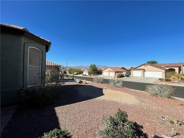 view of yard with concrete driveway and a residential view