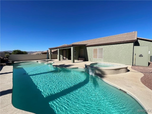 view of swimming pool featuring a pool with connected hot tub, a patio, and fence