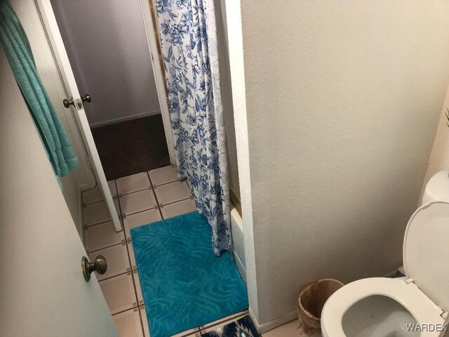 full bath with toilet, shower / tub combo, and tile patterned floors