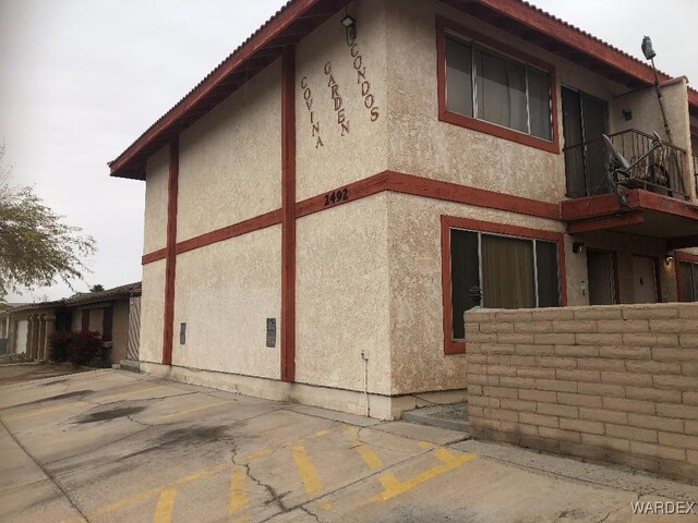 view of property exterior with uncovered parking and stucco siding