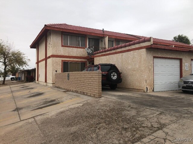 view of side of property featuring a tile roof and stucco siding