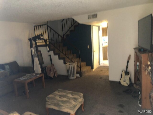 living area featuring carpet floors, visible vents, and stairs