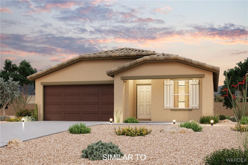 view of front of house featuring driveway, an attached garage, a tile roof, and stucco siding