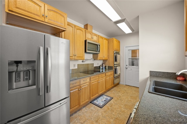 kitchen with a warming drawer, appliances with stainless steel finishes, and a sink