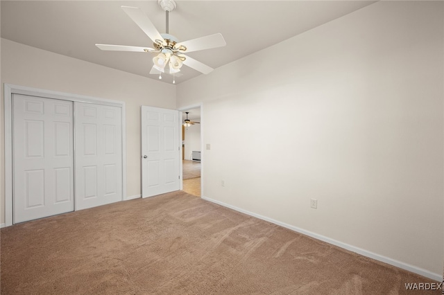 unfurnished bedroom with a closet, ceiling fan, baseboards, and carpet floors