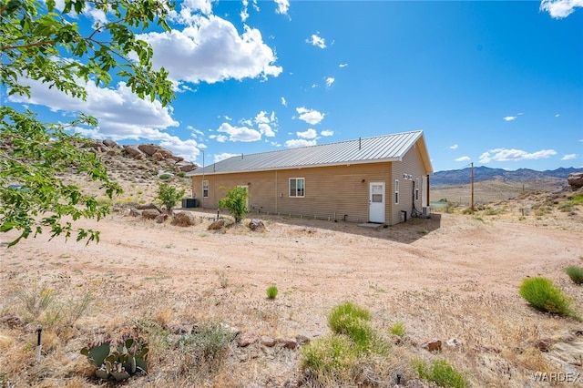 rear view of property with metal roof and a mountain view