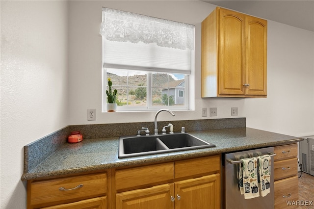 kitchen featuring dark countertops, dishwasher, and a sink