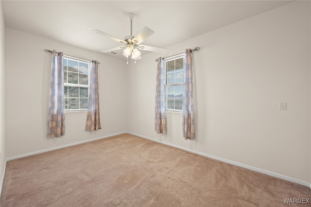 empty room with carpet flooring, baseboards, and ceiling fan