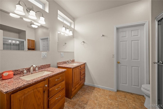 bathroom with a sink, baseboards, two vanities, and a shower stall