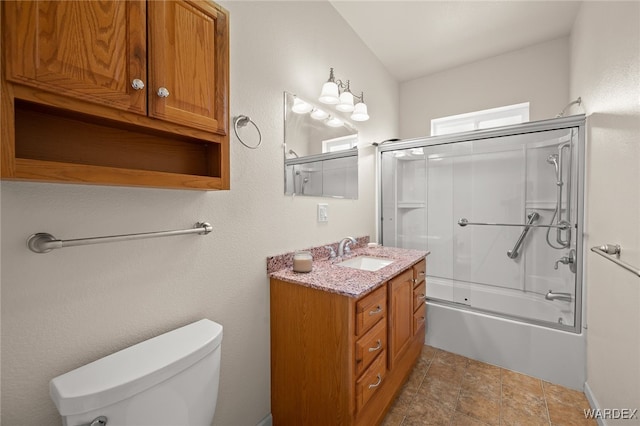 full bath with toilet, vanity, and shower / bath combination with glass door