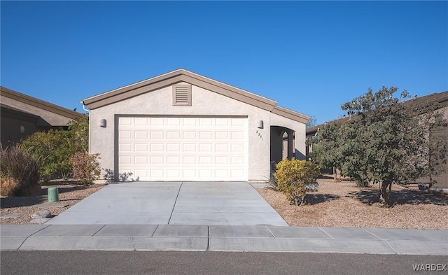 ranch-style house featuring an attached garage, concrete driveway, and stucco siding