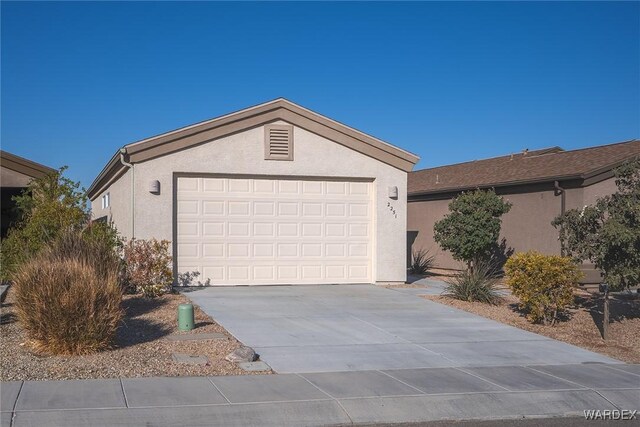 exterior space featuring a garage, concrete driveway, and stucco siding