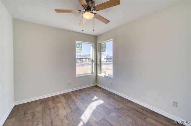 empty room with ceiling fan, wood finished floors, and baseboards