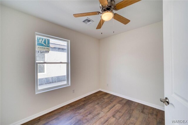 empty room with a ceiling fan, baseboards, visible vents, and dark wood-style flooring