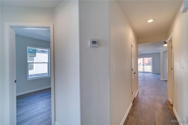 hall with baseboards and dark wood-style flooring