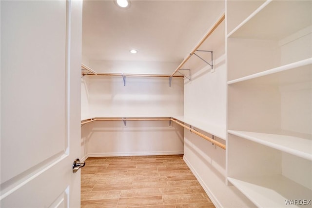 walk in closet with wood finish floors