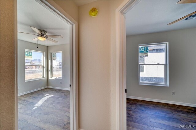 hall featuring baseboards and wood finished floors