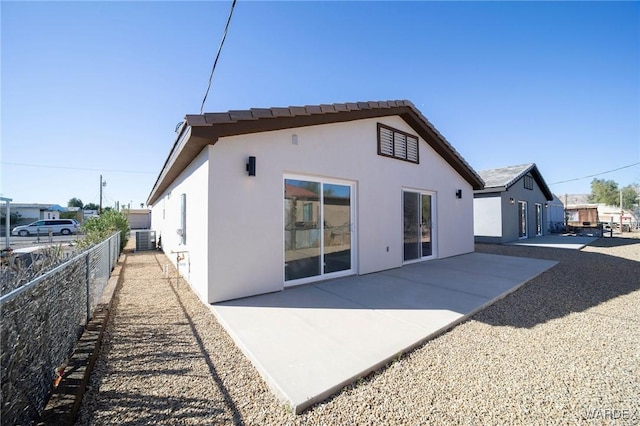 rear view of property featuring central AC, a patio, fence, and stucco siding