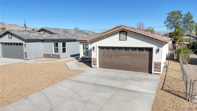 ranch-style house with a garage, stone siding, and stucco siding