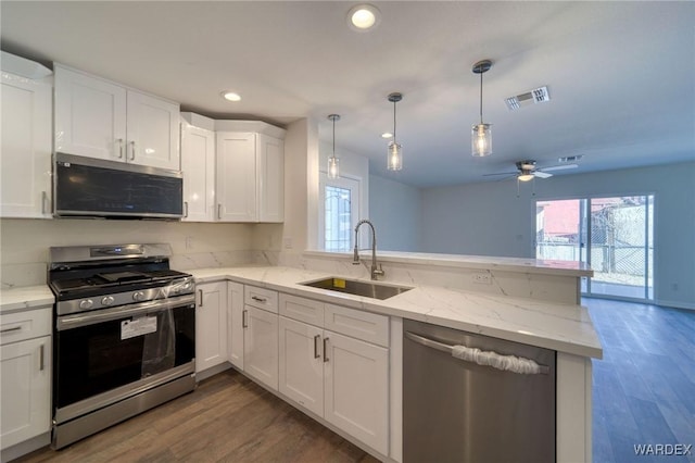 kitchen featuring stainless steel appliances, visible vents, white cabinets, a sink, and a peninsula