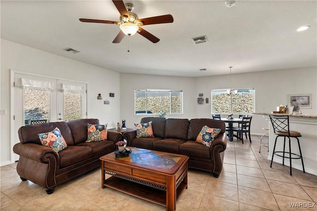 living room with light tile patterned floors, ceiling fan, french doors, and visible vents