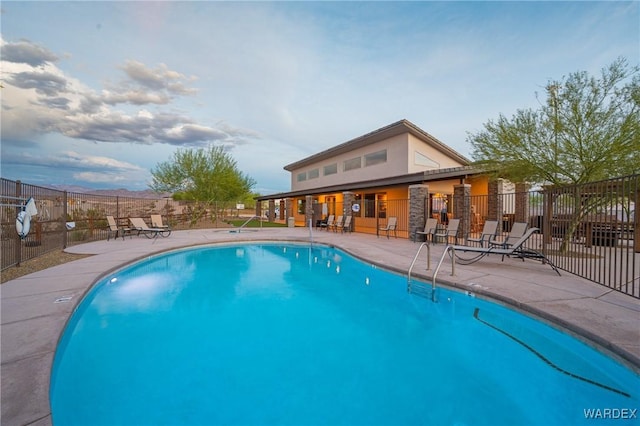 pool with a patio area and fence