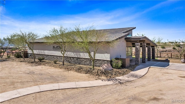 view of home's exterior with fence and stucco siding