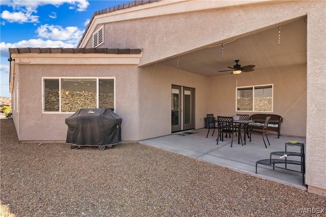 back of property with outdoor dining space, a patio area, a ceiling fan, and stucco siding