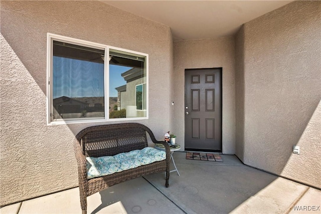 entrance to property featuring stucco siding