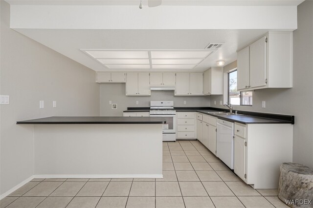 kitchen featuring a peninsula, white appliances, dark countertops, and white cabinets